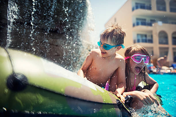 istock Brother and sister playing in pool 547053380