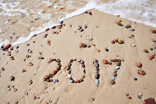 istock Number of wet stones 2017 on sand beach 547054348