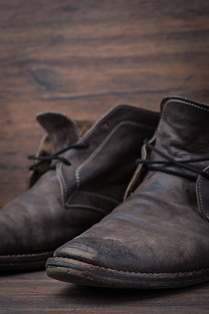 istock Old worn out brown leather shoes over the dark background 547055324