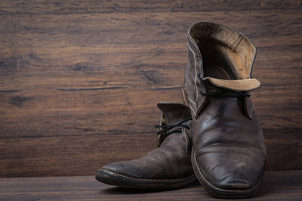 istock Old worn out brown leather shoes over the dark background 547055690