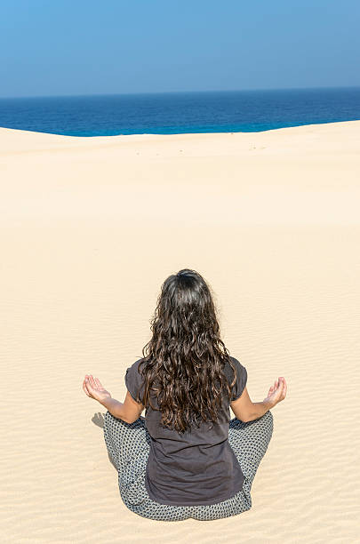 istock Brunette woman doing yoga in a dune. 547055790