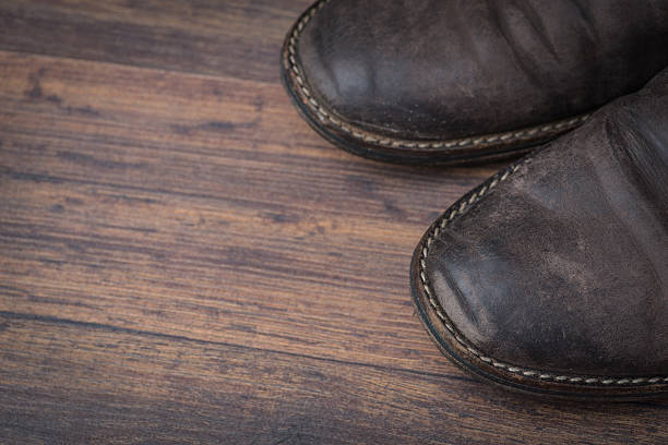 istock Old worn out brown leather shoes over the dark background 547055884