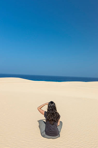 istock Brunette woman doing yoga in a dune. 547056018