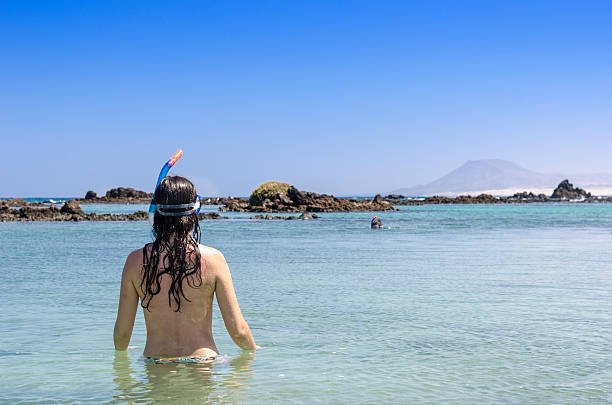 istock brunette woman wearing snorkel and mask 547056542