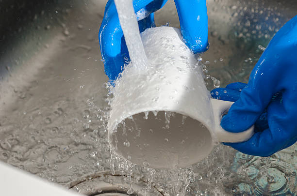 istock woman hands rinsing a glass. 547056846