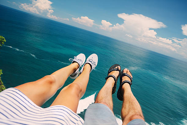 Couple sitting above the ocean stock photo