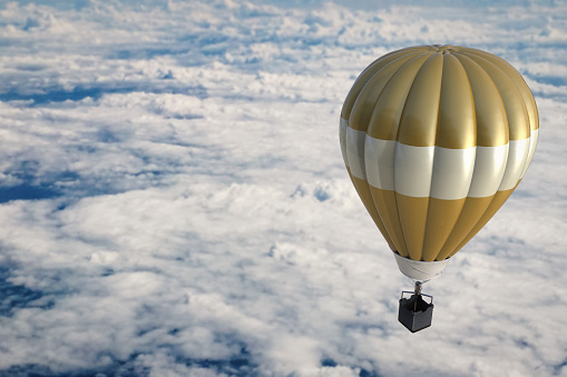 golden hot air balloon above cloudy sky