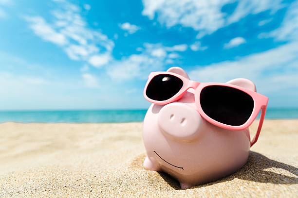 Money Piggy Bank Wearing Sunglasses Relaxing At The Beach holiday sale stock pictures, royalty-free photos & images