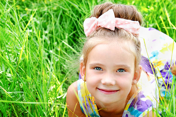 istock Adorable smiling little girl lying on the grass 547126680