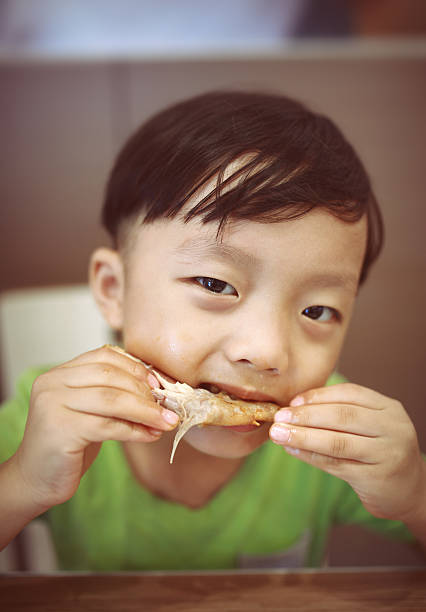 Children eat roast chicken wings