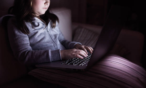 istock Unrecognizable girl, sitting in a dark, playing with laptop 547129314