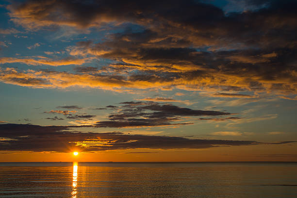 istock Summer sunset on the beach with clouds over the sky 547130342
