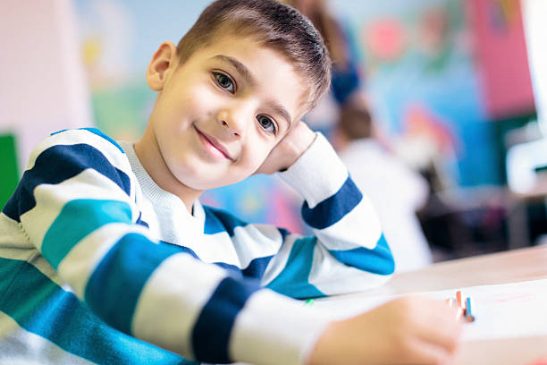 istock Cute boy possing for the camera in the class room 547130952
