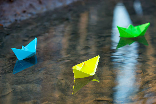 istock Blue paper boat in water 547131030