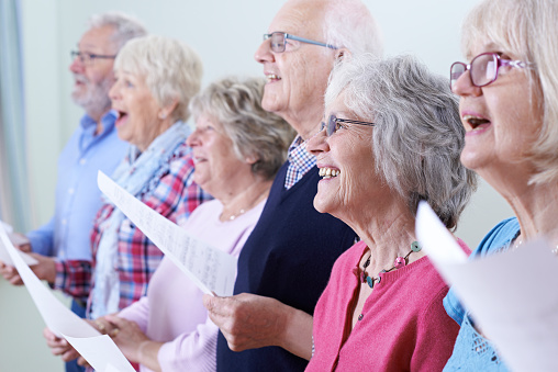 Grupo de personas mayores cantando en coro juntos photo
