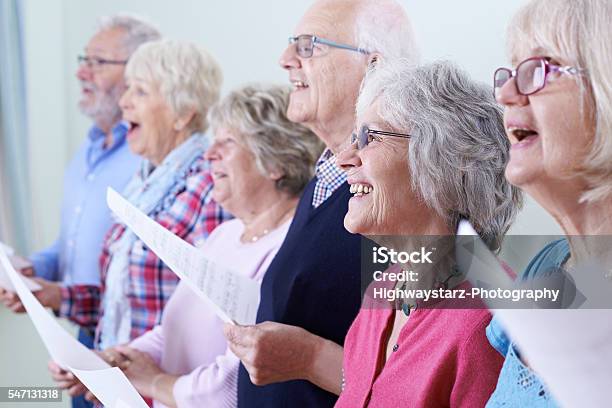 Grupo De Personas Mayores Cantando En Coro Juntos Foto de stock y más banco de imágenes de Tercera edad - Tercera edad, Cantar, Coro