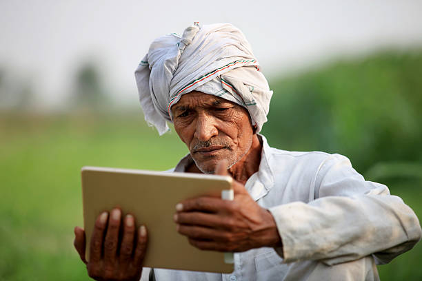 vecchio agricoltore in possesso di tablet digitale - poor communication foto e immagini stock