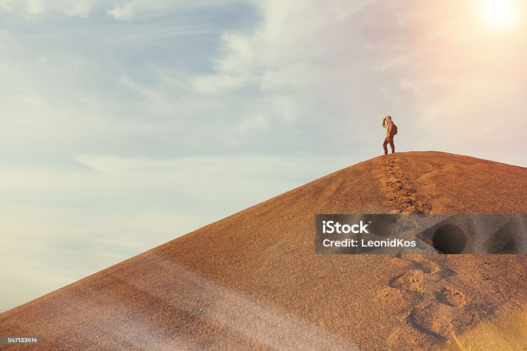 Man on top of a dune in the desert Man on top of a dune in the desert. Warm color Desert Area Stock Photo