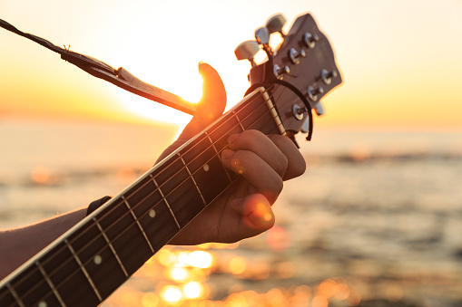 Young guy playing a guitar at sunset(Soft Focus)