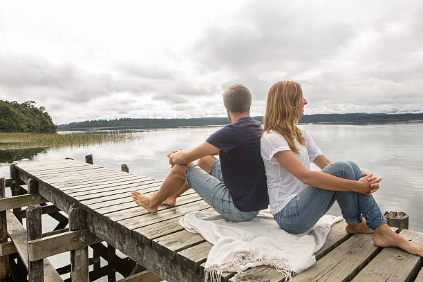 istock Cheerful young couple relaxing on lake pier 547135464
