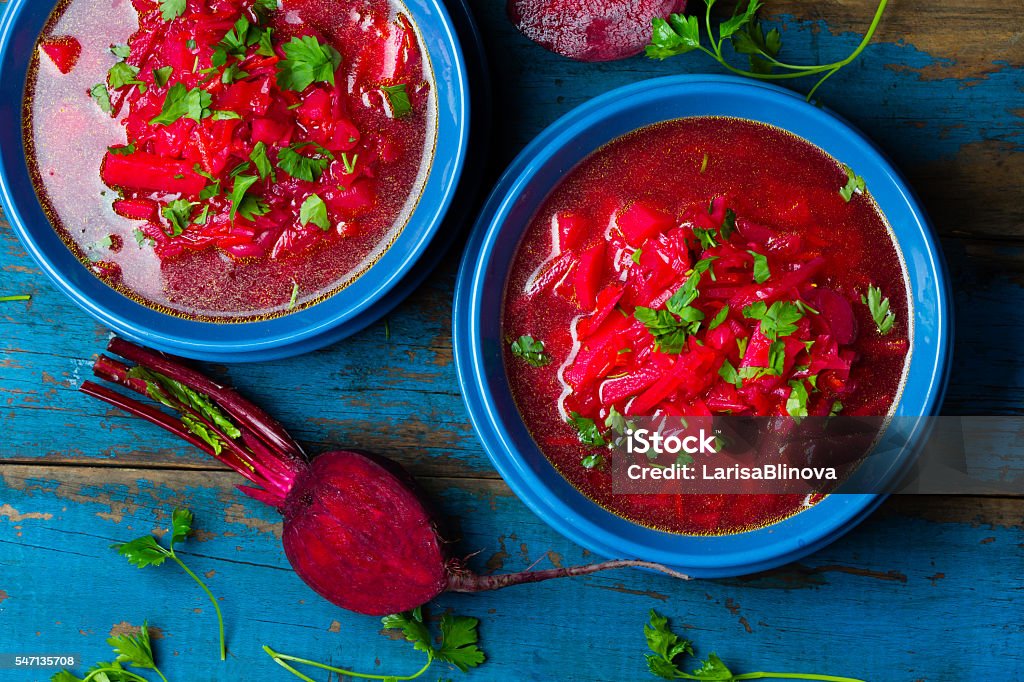 Borsh. Russian and Ucrainian traditional vegetarian red soup. Top view Russian and Ucrainian traditional vegetarian red soup - borsch in blue plates on wooden background. Top view Borscht Stock Photo