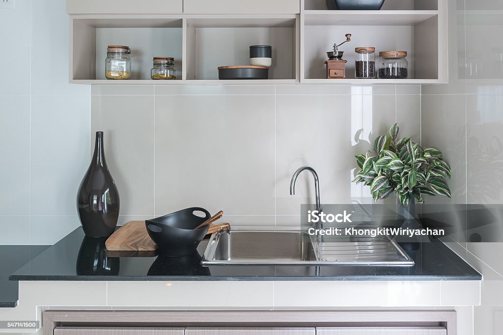 modern sink on black kitchen counter modern sink on black kitchen counter with vase of plant Burner - Stove Top Stock Photo