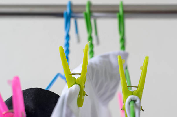 The clothespin and white shirts drying on a clothes line.