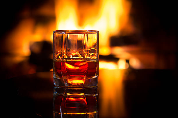 Glass alcoholic drink wine in front warm fireplace. stock photo