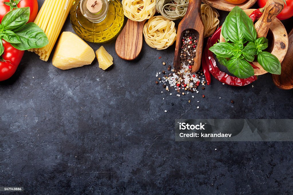 Italian food cooking Italian food cooking. Tomatoes, basil, spaghetti pasta, olive oil and chili pepper on stone kitchen table. Top view with copy space for your recipe Backgrounds Stock Photo