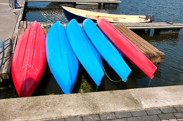 Colorful small boats stacked along wooden pier