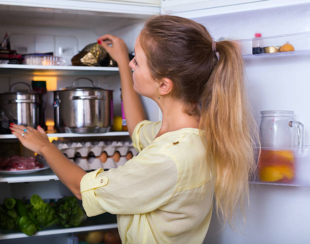 istock Cheerful woman searching in refrigerator 547144532