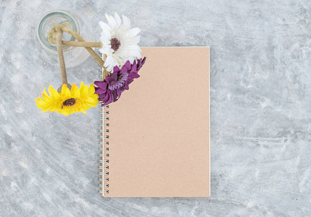 istock Brown note book with blurred artificial flower on glass bottle 547147428