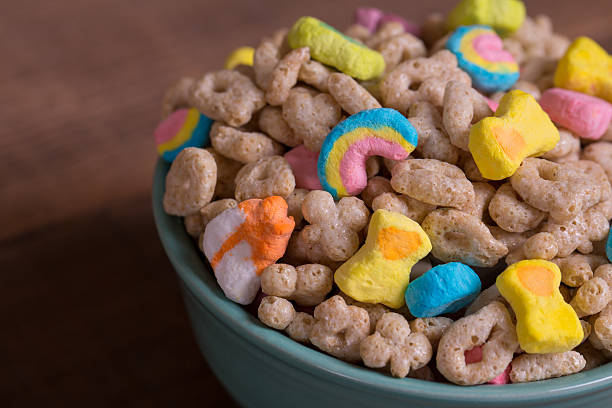Marshmallow Cereal on Weathered Wood Colorful marshmallow cereal in a blue bowl on a weathered wood background breakfast cereal photos stock pictures, royalty-free photos & images