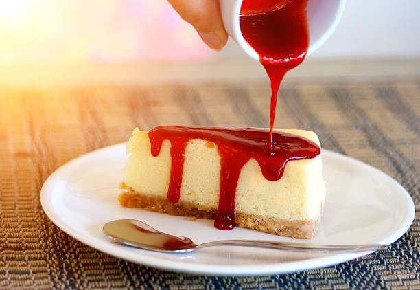 istock Pour strawberry sauce into cheesecake 547150538