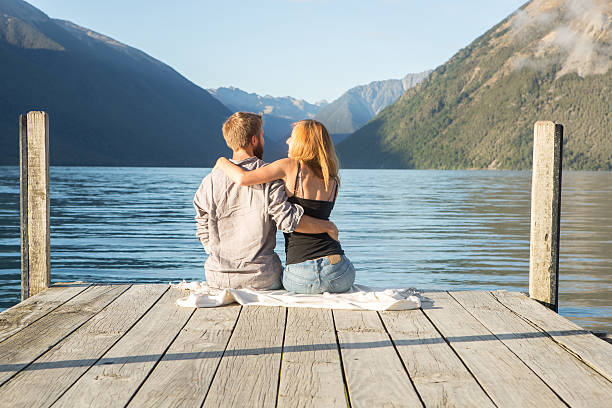 istock Young couple cuddling on lake pier 547151776