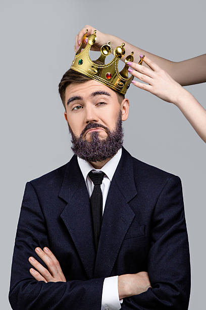 istock Funny young man posing when girls hands holding crown 547155150