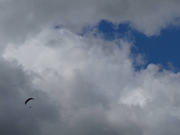 istock Paraglider against clouds and blue sky 2 547157918