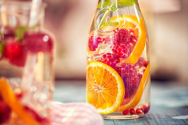 Infused Water with Fresh Raspberries, Lemon, Pomegranate and Mint Infused water with fresh raspberries, lemon, pomegranate and mint served in a glass jar. infused water stock pictures, royalty-free photos & images