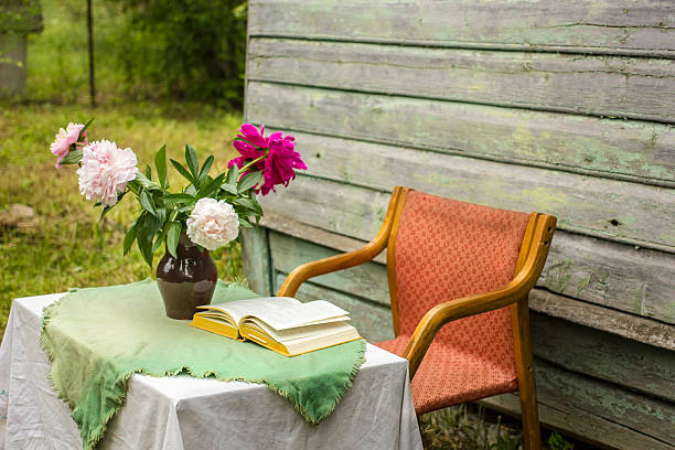 istock Vase of beautiful peony and a closed book on table 547160726