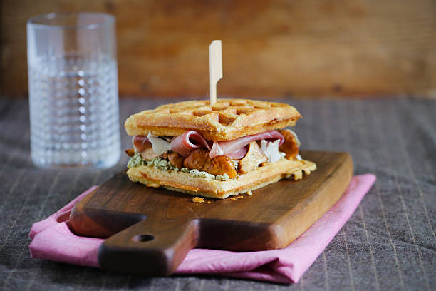 sandwich gaufre au prosciutto, chanterelles et farine de fromage à la crème - waffle sausage breakfast food photos et images de collection