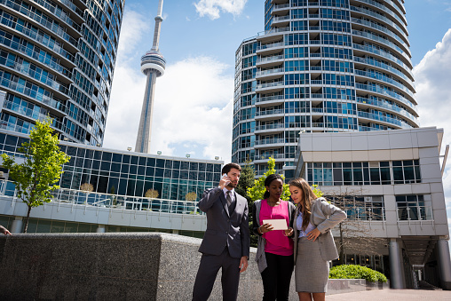 Young group of business professionals with the CN Tower in the background in Toronto