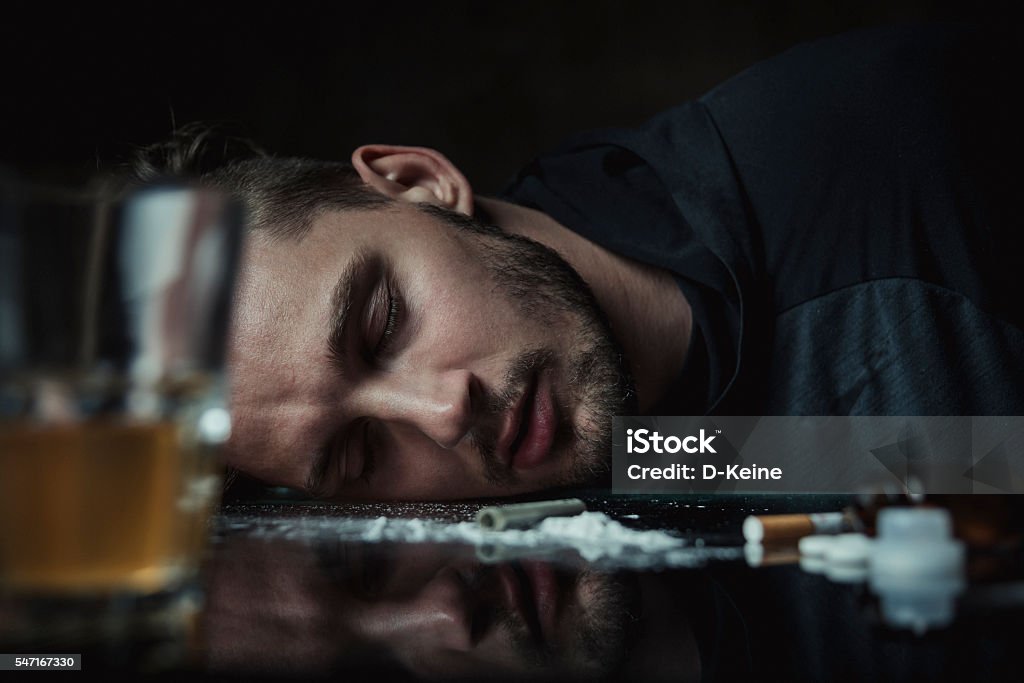 Cocaine Overdosed man after snorting cocaine in dark room. Drug addict concept. Abuse Stock Photo