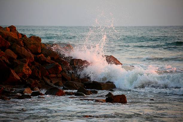 meereswellen rauschen während des sonnenuntergangs gegen das riff. - sunset beach sky heat stock-fotos und bilder