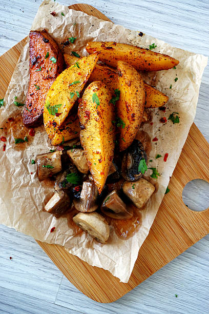 Baked potato and mushroom slices on wooden table