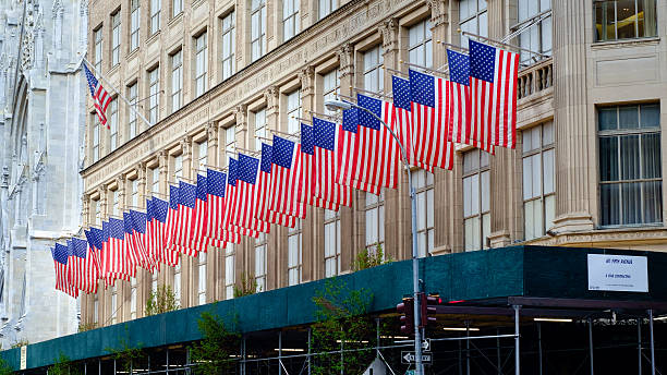 rangée de drapeaux américains sur sa cinquième avenue, new york - saks fifth avenue photos et images de collection