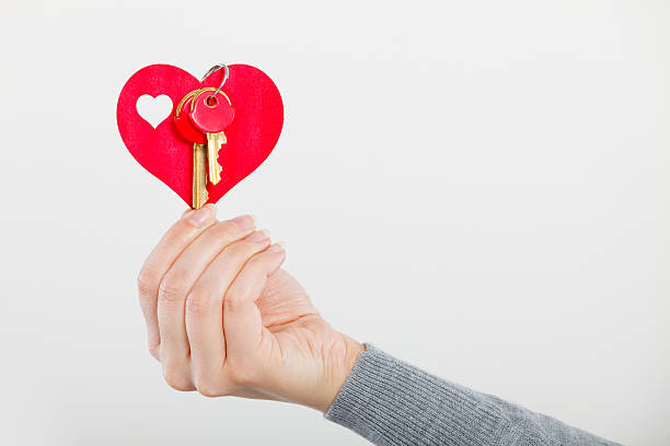 istock Female hand holds little heart with keys. 547210972