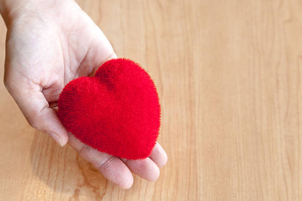 istock Red heart in hand wooden background 547211242