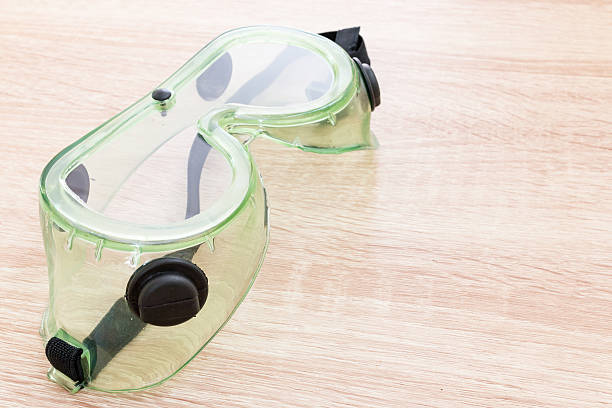 istock Safety glasses on wooden background 547211422
