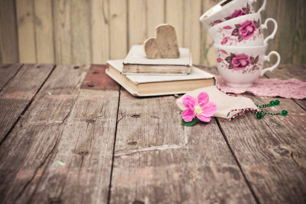 istock Pink Flower, old books, tea cups on rustic wooden table 547212666