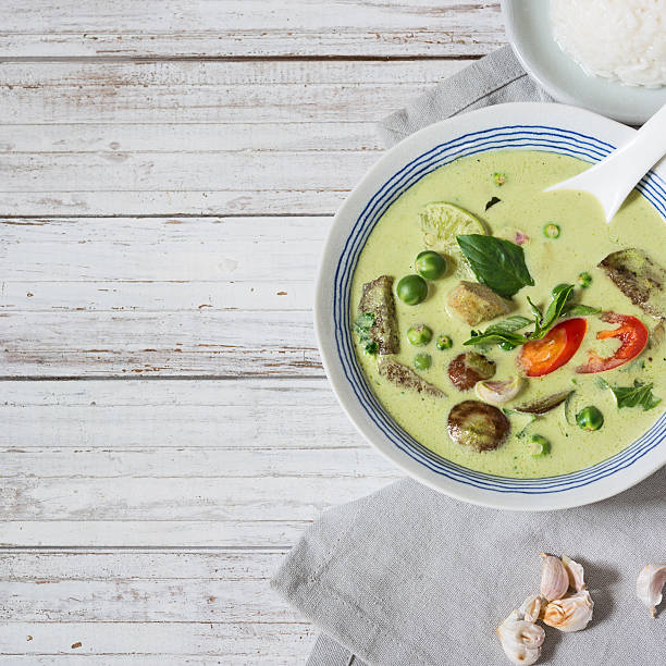 istock Green curry in the bowl on the white wooden table. 547213928